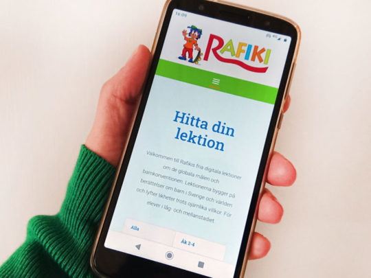 Hand som håller i en telefon.