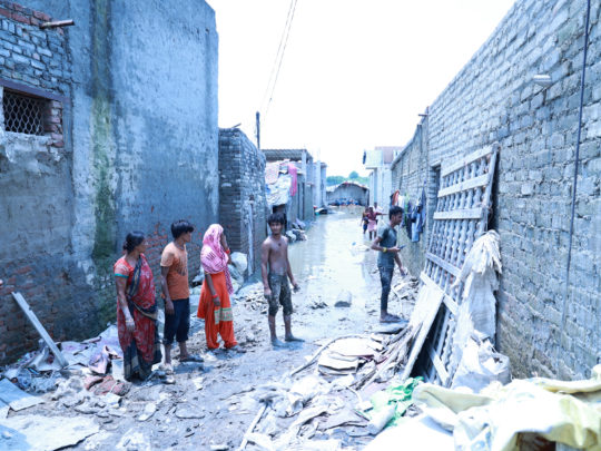 Människor som står på gatan i ett katastrofdrabbat område i norra Indien.