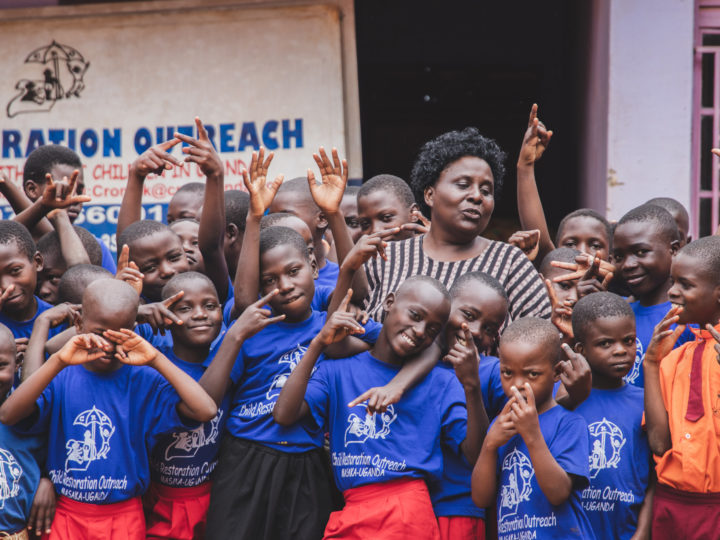 En samling av barn på ett dagcenter för gatubarn, tillsammans med en av deras handledare.