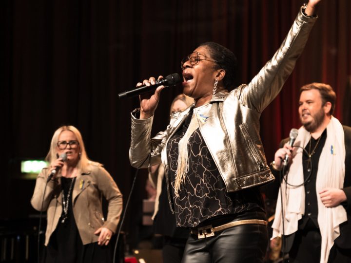 Gladis del Pilar sjunger och sträcker ut en arm. 