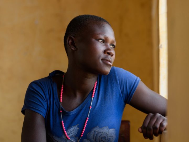 En kvinna tittar ut genom fönstret.