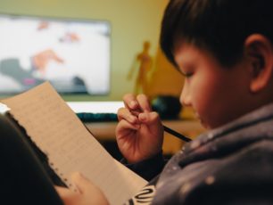 En pojke skriver en önskelista till jul.