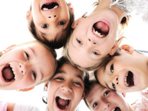 Barn som är glada och gapar stort mot kameran.